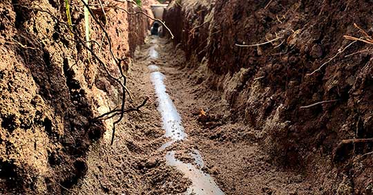 Image of a new sewer line in a freshly dug trench.